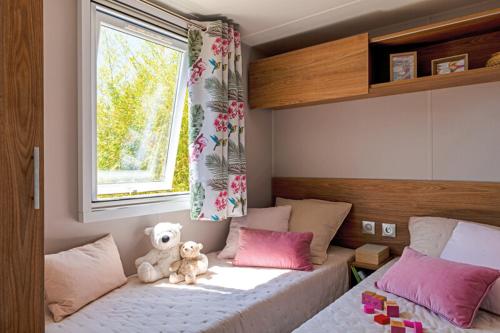 a bedroom with a bed with a teddy bear sitting on it at Beachside Vakantiepark in Blankenberge