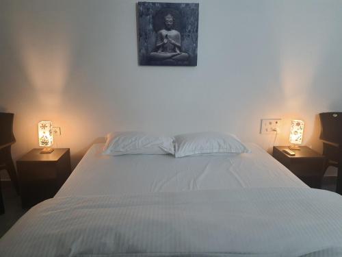 een slaapkamer met een bed met een foto aan de muur bij Auro Maison in Pondicherry