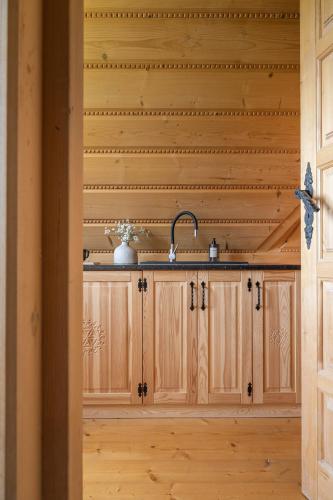 a kitchen with wooden cabinets and a sink at Wierchowa Chata in Kościelisko