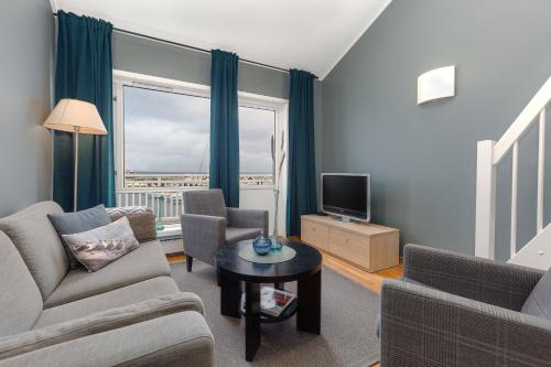 a living room with a couch and a tv at Kjerringøy Bryggehotell in Bodø