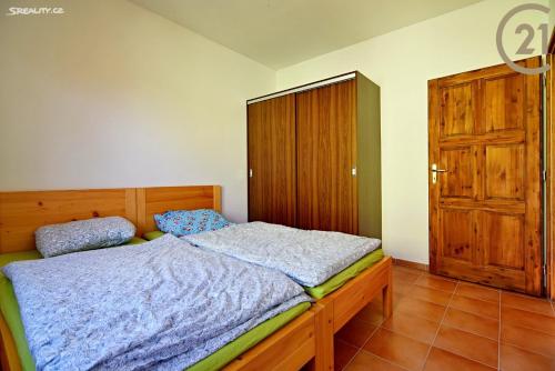 ein Schlafzimmer mit einem Holzbett und einer Holztür in der Unterkunft Apartmán Slapy, slapská přehrada - Nová Živohošť in Křečovice