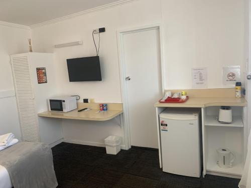 a room with a desk and a table with a microwave at Charlton Motel in Charlton