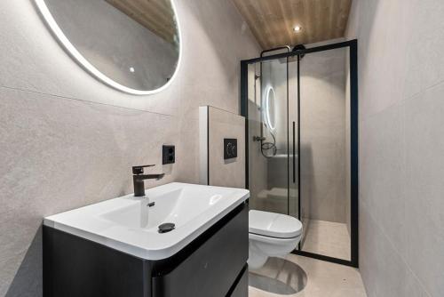 uma casa de banho com um lavatório, um WC e um espelho. em Panorama Hovden - New Cabin With Amazing Views em Hovden