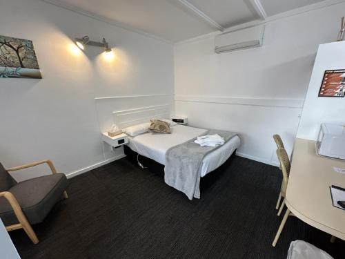 a small room with a bed and a chair at Charlton Motel in Charlton