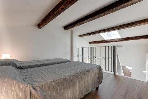 フィレンツェにあるPalazzuolo Homeの梁出し天井のベッドルーム1室(ベッド1台付)