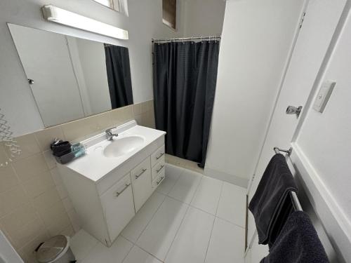 La salle de bains blanche est pourvue d'un lavabo et d'un miroir. dans l'établissement Charlton Motel, à Charlton