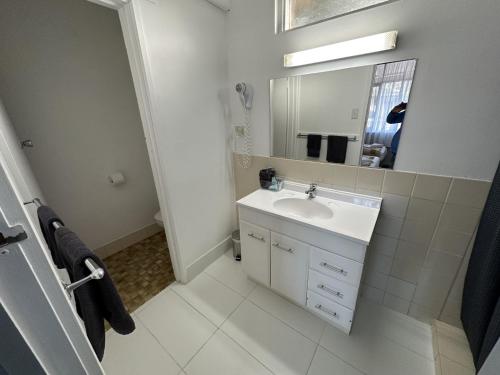 a white bathroom with a sink and a mirror at Charlton Motel in Charlton