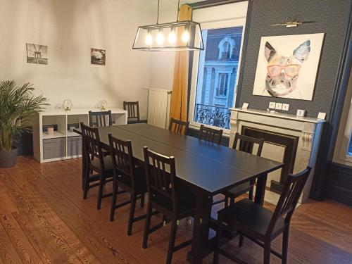 a dining room with a black table and chairs at Le Sunshine, 5 chambres, wifi et parking inclus in Le Coteau