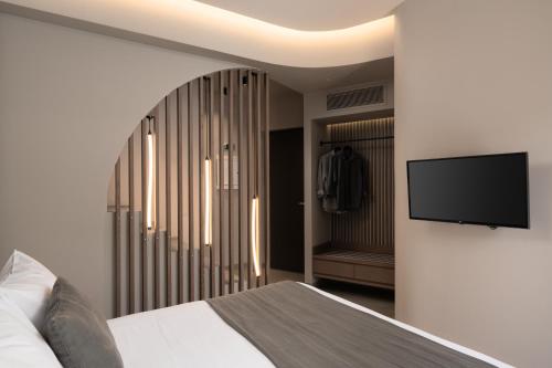 a bedroom with a bed and a tv on a wall at Apikia Santorini in Pirgos
