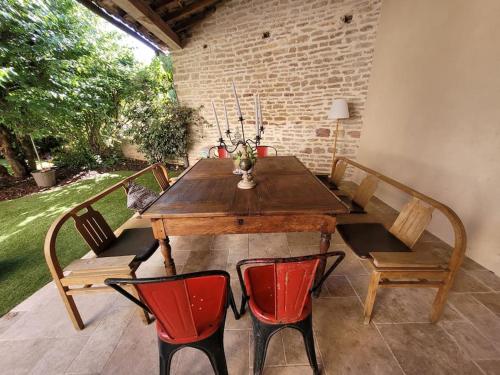 博恩的住宿－Grande maison Brocante avec piscine proche centre，庭院里配有一张木桌和椅子,配有桌子和长椅
