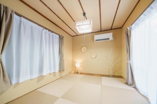 um quarto com uma grande janela e piso em azulejo branco em R-house 2nd 横浜 em Higashi-kanagawachō