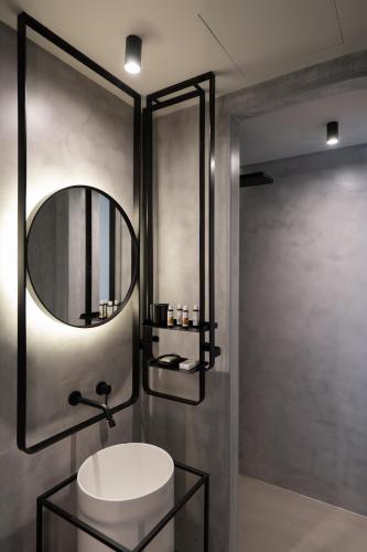 a bathroom with a sink and a mirror at Apikia Santorini in Pirgos