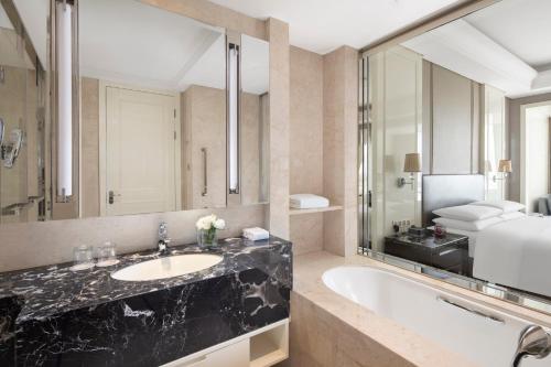 a bathroom with a sink and a large mirror at Zhejiang Taizhou Marriott Hotel in Taizhou