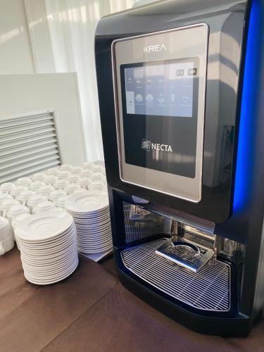 un monitor di computer posizionato accanto a una pila di piatti di Hotel Columbia Frontemare a Rimini