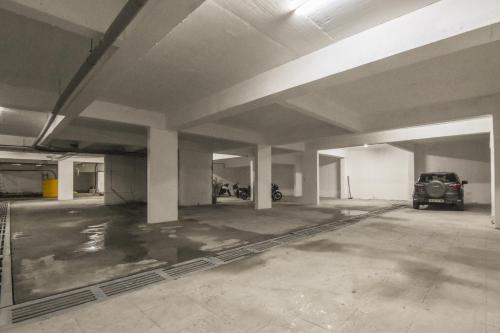 an empty parking garage with a car parked in it at Suraksha Stay Whitefield Hotel in Bangalore