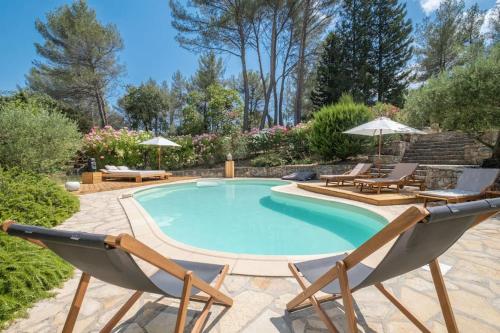 einen Pool mit zwei Gartenstühlen und einem Pool in der Unterkunft Rêves de pampa Casa Bohème in Lorgues