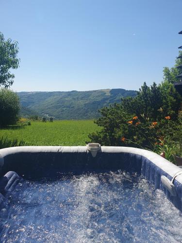 - un bain à remous dans l'arrière-cour avec vue sur un champ dans l'établissement La Colline du Chat Perche, à Connac