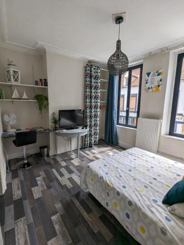 une chambre avec un lit, un bureau et une télévision dans l'établissement Appartement privé hyper centre de Boulogne S/Mer, à Boulogne-sur-Mer