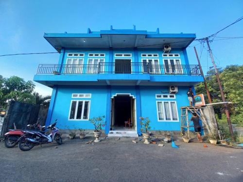niebieski dom z balkonem na górze w obiekcie Tangkoko Safety Stop w mieście Bitung