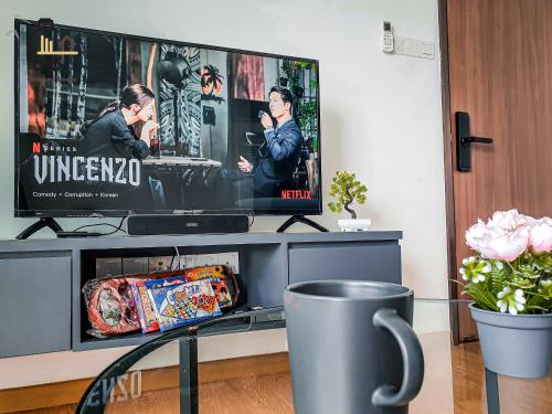 a living room with a tv and a table at 1 min to Seaview & Sunrise Heart of Kuantan in Kuantan