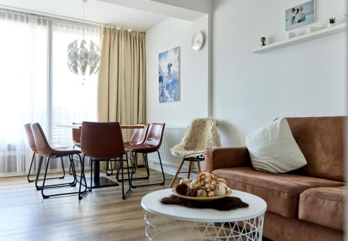 a living room with a couch and a table and chairs at Schima Drosa Apartments - Studios - by Pferd auf Wolke in Gaschurn