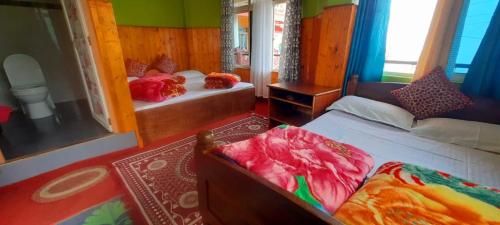 1 Schlafzimmer mit 2 Betten und einem Spiegel in der Unterkunft Bethel Homestay, Darjeeling in Darjeeling