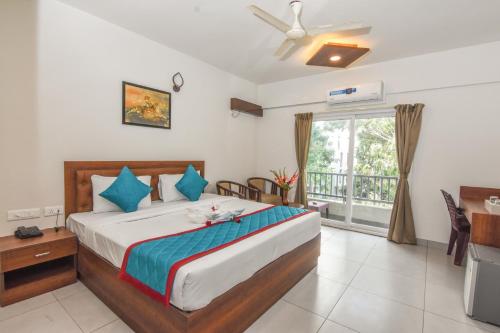 班加羅爾的住宿－Suraksha Stay Whitefield Hotel，一间带大床的卧室和一个阳台