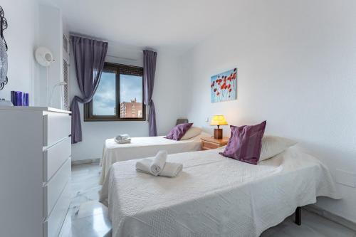 een slaapkamer met 2 bedden met paarse kussens bij Apartamento Encantador vista Mar in Fuengirola