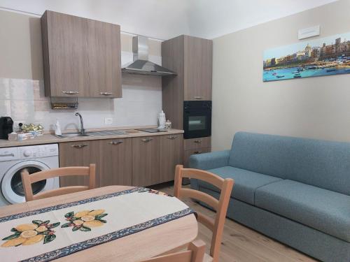 ein Wohnzimmer mit Couch und Küche in der Unterkunft La Cocorita in Trapani