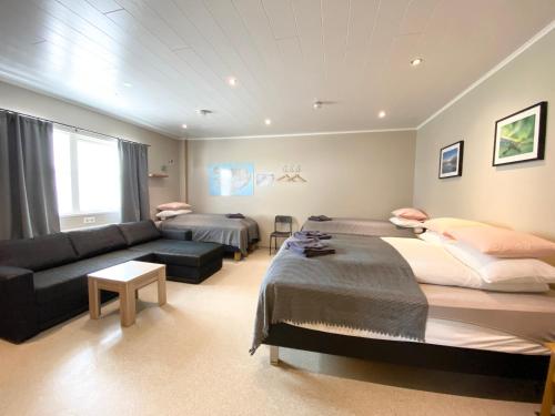 ein Wohnzimmer mit 2 Betten und einem Sofa in der Unterkunft Studio Apartments in Seyðisfjörður