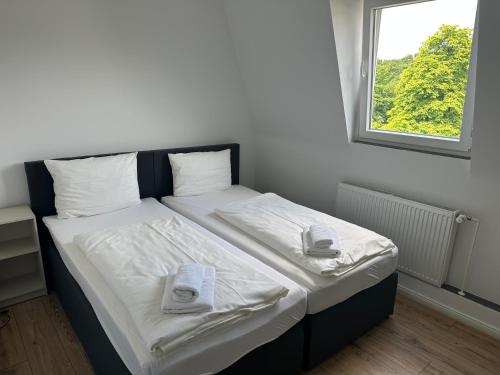 a bed in a room with two towels on it at Pension Hygge am Hafen in Flensburg