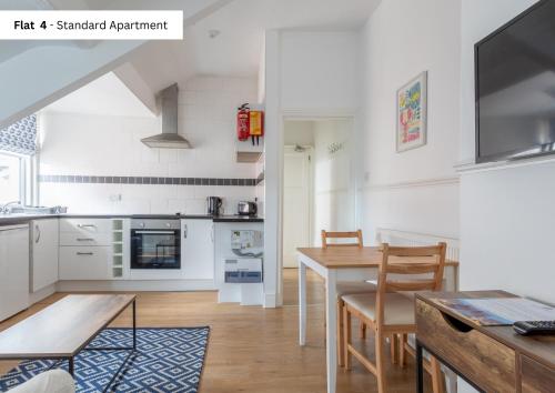 a kitchen and dining room with a table and chairs at The Chymes Holiday Flats in Lytham St Annes