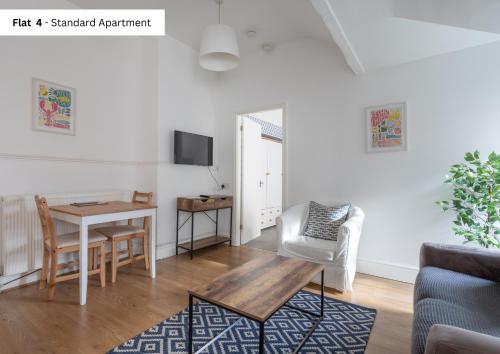 a living room with a table and a desk at The Chymes Holiday Flats in Lytham St Annes