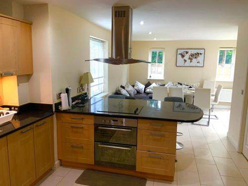 a kitchen with a counter top and a living room at Large Executive 4-Bed Detached House in Miskin, Cardiff-sleeps up to 10 in Hensol