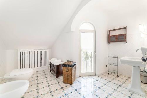 a white bathroom with a toilet and a sink at Amalfi coast-Praiano Villa Cristina no steps in Praiano