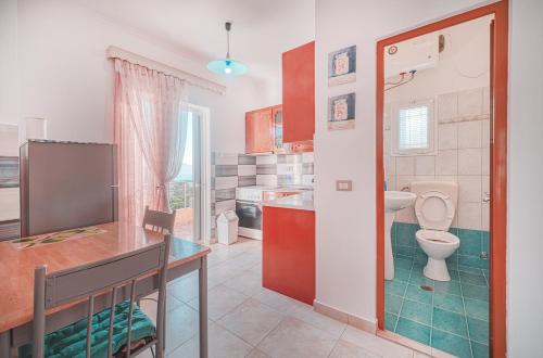 a bathroom with a toilet and a sink in a kitchen at Mirror Beach Ksamil - Vila Zervo in Sarandë