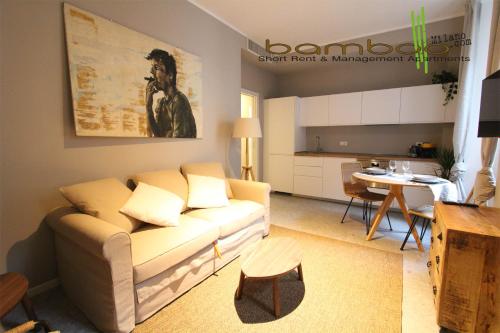 sala de estar con sofá y cocina en Bamboo Milano Umbria Apartment, en Milán
