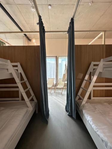 a room with two bunk beds and a window at Ohmaria Hotell, del av Ohboy Hotell in Höllviken