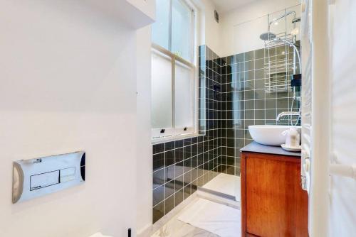 La salle de bains est pourvue d'un lavabo et d'un miroir. dans l'établissement Beautiful 1 bedroom apartment in Shepards Bush, à Londres