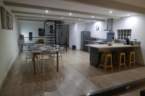 une cuisine et une salle à manger avec une table et des chaises dans l'établissement Loft Porte Sud, à Salles-d'Aude