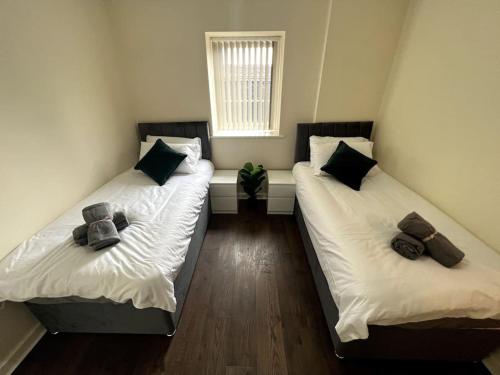 two twin beds in a room with a window at Wi-Fi, 2 bathroom, 2 bedroom, sleeps 4-8 in Birmingham