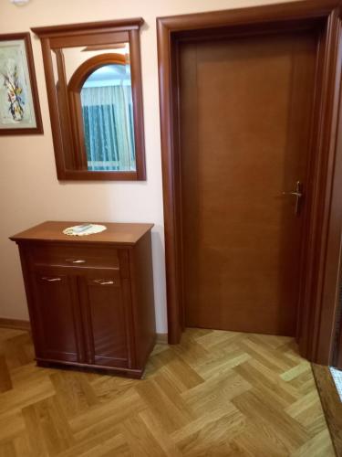 a room with a wooden door and a mirror at Apartman Maja in Sveti Stefan