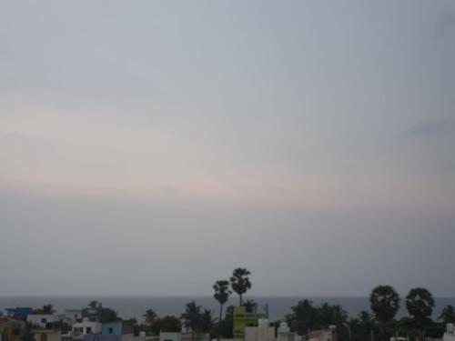 a city skyline with palm trees and buildings at Auro Maison in Puducherry