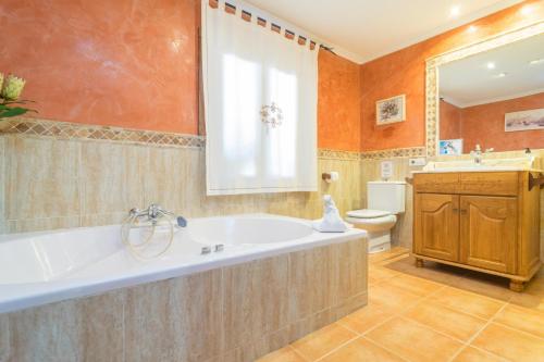 a bathroom with a tub and a toilet and a sink at Finca Miralles in Búger