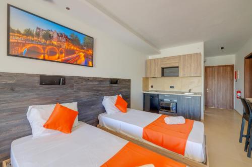 een slaapkamer met 2 bedden en een tv aan de muur bij Bayside A Apartments in St Julian's
