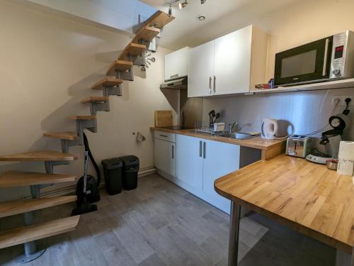 une cuisine avec un escalier en colimaçon dans une pièce dans l'établissement Appart à coté de la vieille ville de Boulogne sur mer, à Boulogne-sur-Mer