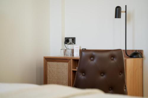 a brown chair sitting in front of a desk at Fritiden Hotell & Kongress in Ystad