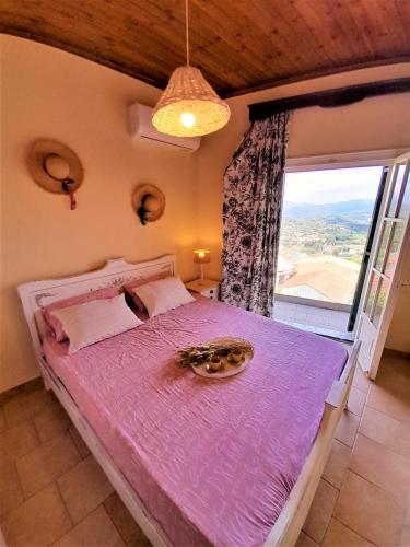 a bedroom with a purple bed with a large window at VILLA CHRYSANTHOS in Ágios Matthaíos