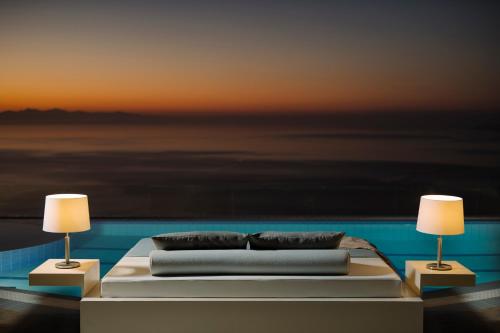 1 cama con almohadas y 2 lámparas en una habitación en Emerald Deluxe Villas, en Agios Nikolaos