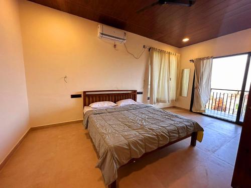 a bedroom with a bed in a room with a window at VIDHI VILLA -Besides Valley View 360 with Luxurious Swimming pool & AC in Mahabaleshwar